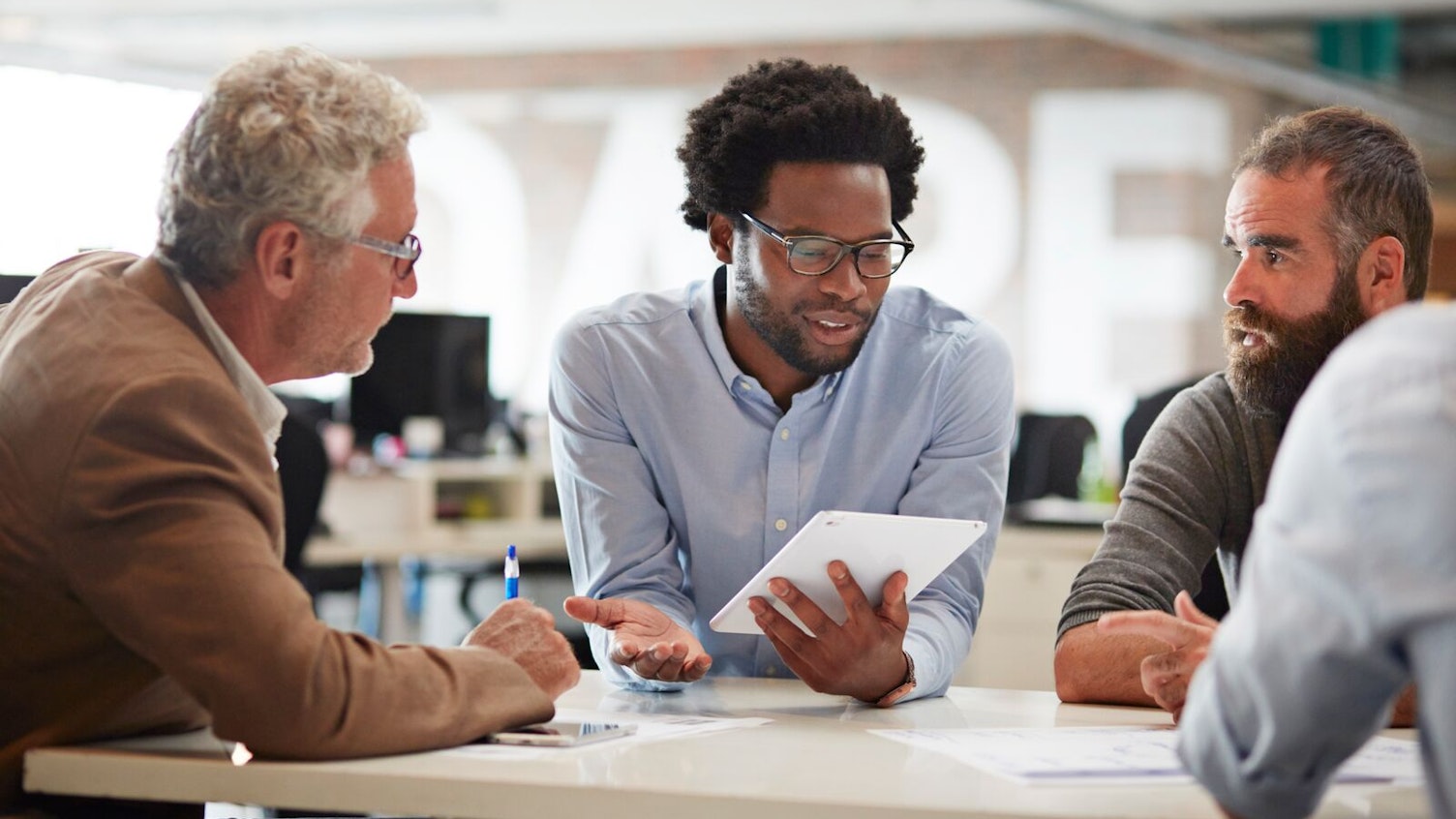 Business Colleagues Discussing a Project Using Tablet